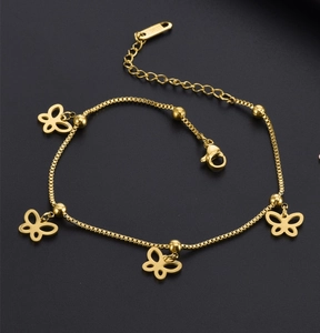 Detail of gold box chain bracelet featuring hollow butterfly charms and round beads