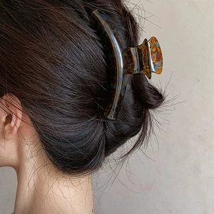 Deep amber acetate shark hair claw clip showing a stylish tortoise shell pattern on hair