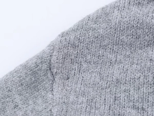 Macro shot of gray hooded cardigan showing thick knit texture and shoulder seam stitching