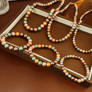 Vue détaillée des bracelets et colliers de perles en tons marron, bleu sarcelle et orange