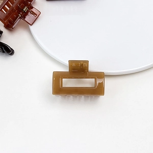 Detailed macro view of square hollow hair claw clip with amber jelly resin texture