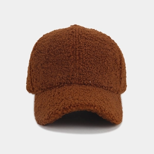 Close-up of brown thickened faux shearling fabric texture on a winter baseball cap