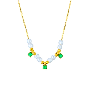 Detail of gold chain necklace featuring white pearls and emerald green square gemstones
