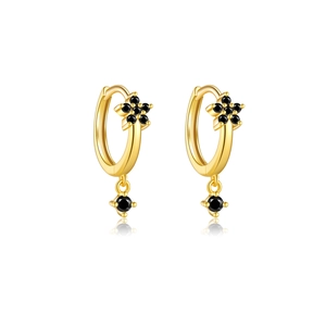 Detail of gold flower hoop earrings with black gemstones and elegant mirror reflection