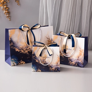 Three premium blue marble gift bags with gold ribbons and sweet times branding