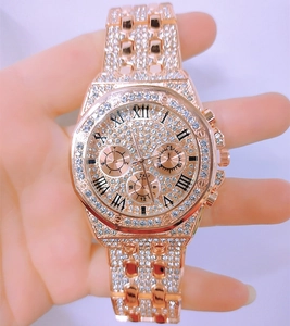 Detail of rose gold diamond watch featuring an octagonal bezel and Roman numerals