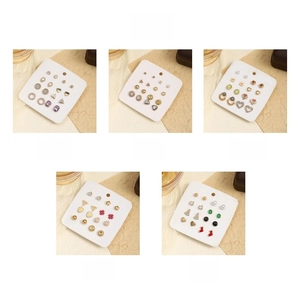 Detail showing assorted metal stud earrings in silver, gold, and colorful enamel finishes