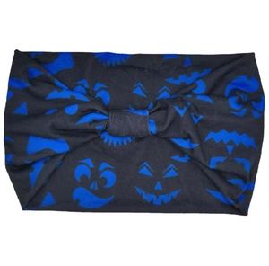 Detail of black knotted headband featuring blue pumpkin ghost patterns for Halloween
