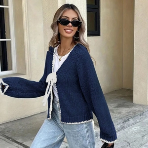 Detail of navy knit cardigan with white crochet trim and bow tie front for women