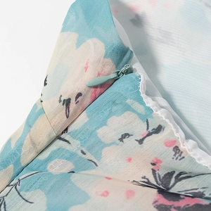 Dettaglio della cerniera invisibile su un abito lungo in chiffon con stampa floreale
