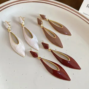 Three pairs of retro water drop earrings in white, red and brown with gold frames