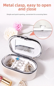 Detail of oval white PU leather jewelry box featuring a vanity mirror and ring slots