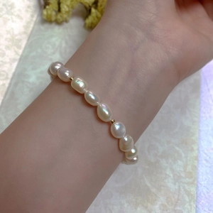 Detailed view of baroque pearl bracelet with 14K gold accents on female wrist