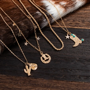 Detail view of 4-piece Western gold necklace set with cactus and cowboy charms