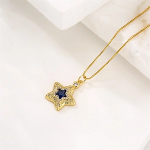 Collier doré avec pendentif étoile, zircon bleu foncé et cristaux sur fond marbre
