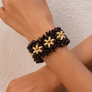 Détail d'un bracelet bohème fait main en perles de bois avec motifs de fleurs