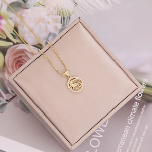 Detailed top view of 18K gold zodiac pendant with micro-inlaid diamonds on jewelry box