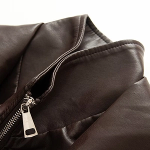 Gros plan sur la veste en similicuir marron vieilli avec fermeture éclair et coutures