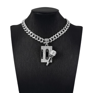 Detail of silver iced-out cuban chain necklace with microphone and tape pendants