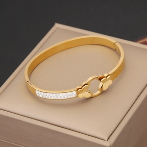 Detailed macro view of golden butterfly bangle with pavé crystals on a jewelry gift box