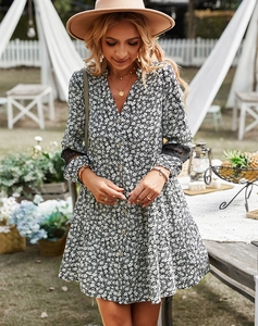 Detail of delicate lace stitching on the cuffs of a floral V-neck long sleeve dress