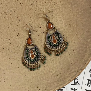 Boucles d'oreilles bohèmes vintage en métal bronze et perles colorées sur plateau