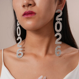 Close-up of model wearing sparkly silver 2026 number drop earrings with rhinestones