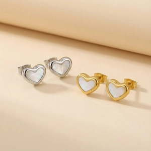 Dettaglio macro di orecchini a cuore con inserto in madreperla in oro e argento