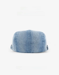 Detail of washed blue denim docker cap featuring adjustable buckle and neat stitching