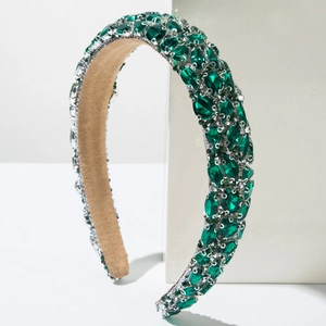 Macro detail of luxury baroque headband with emerald crystals and suede lining