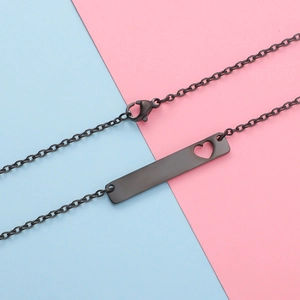 Detailed view of black rectangle bar pendant with hollow heart cutout and matching link chain