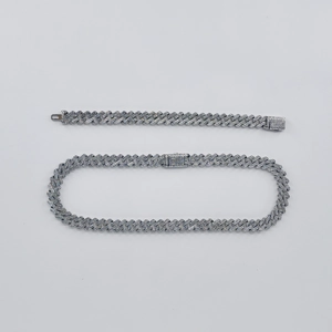 Silver iced out Cuban link necklace and bracelet set with sparkling diamonds on grey background