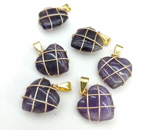 Detailed view of six heart-shaped amethyst pendants with gold wire wrapping technique