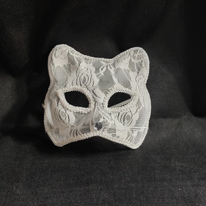 Detailed view of white floral lace cat mask with heart gem and wire whiskers