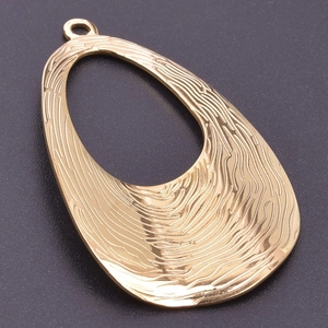 Macro shot of gold textured geometric pendant with asymmetric wood grain engraving