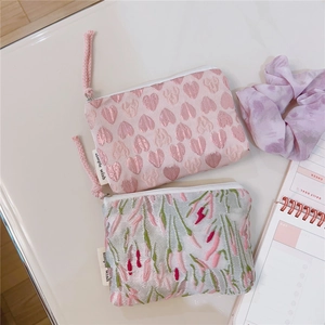 Detail view of pink heart and tulip floral embroidery on small zipper storage pouches