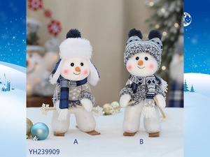 Detail of cute plush snowmen with miniature wooden skis and knitted winter scarves