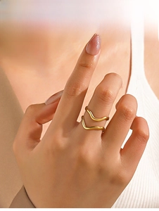 Macro shot of minimalist gold irregular wavy ring worn on finger by a model