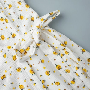Détail de robe en coton à fleurs avec imprimé roses jaunes et détail de ruban à la taille
