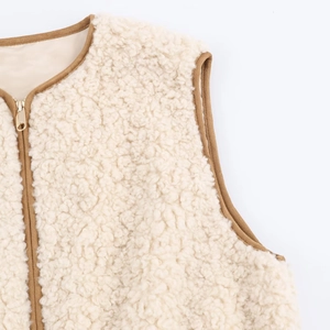 Detailed macro view of cream fleece vest with brown piping and gold metal zipper detail