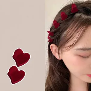 Red velvet heart claw clip worn by a model to style elegant hair braids