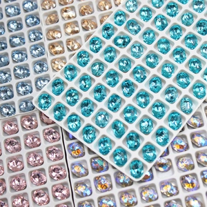 Macro view of faceted oval rhinestones in light blue and champagne for nail art decoration