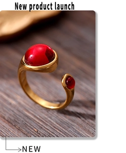 Macro shot of gold-plated ferris wheel ring with red garnets on wood background