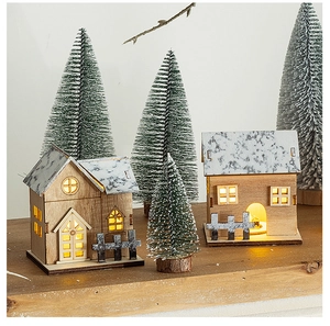 Detail of wooden LED Christmas village with snow-roofed houses and mini sisal trees