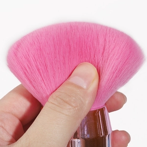 Close-up of soft pink mushroom makeup brush bristles showing fluffiness and texture
