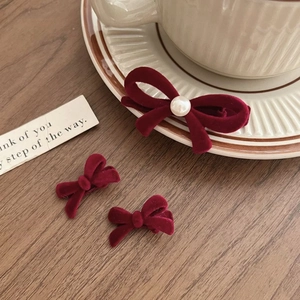 Vintage Set aus weinroten Samt-Haarspangen mit Perlen auf einem Holztisch