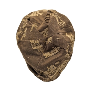 Detail view of brown knitted beanie showing vintage letter patterns and thick ribbed texture