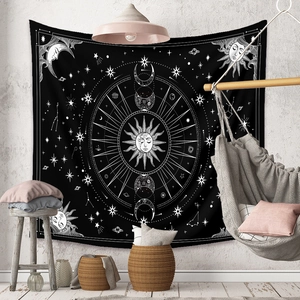 Bohemian black and white wall tapestry with sun and moon phases in a cozy room setting