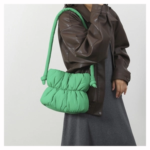 Detail of vivid green ruched nylon puffer bucket bag with knotted shoulder strap