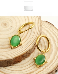 Detail von Vintage 18K Goldohrringen mit grünen Katzenaugensteinen auf Holz